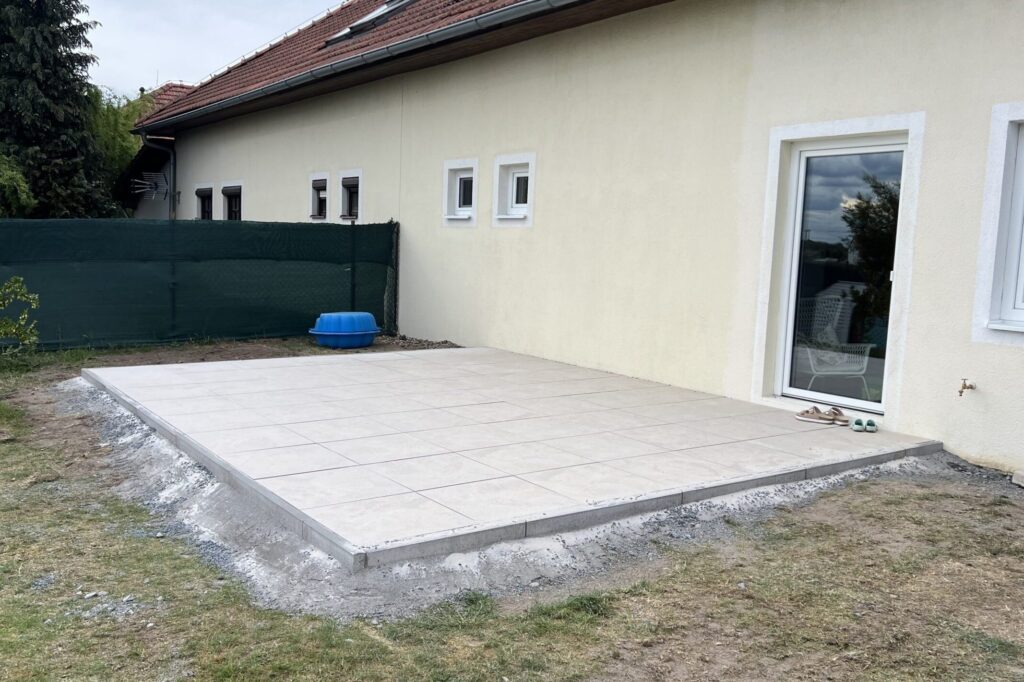 Hotová zahradní terasa s velkoformátovou dlažbou u rodinného domu